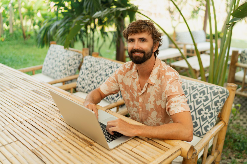 A local Balinese person working on a laptop in a lush green co-working space, with a professional CeeVee resume template visible on the screen.